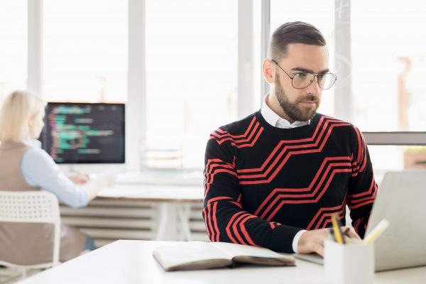 Concentrated copywriter working with laptop